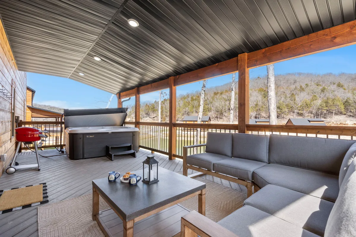 Featured here is another angle of the private deck, focusing on the hot tub, a well-arranged outdoor seating area, a table with decorative touches, and a grill. The image radiates a sense of sociability and comfort, suggesting lively evenings, outdoor meals, and shared moments.